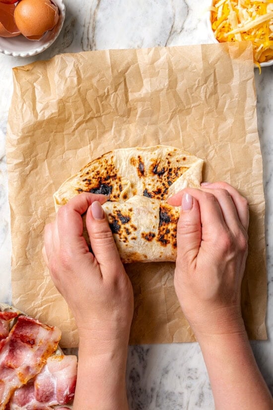 Folding breakfast burrito in tortilla