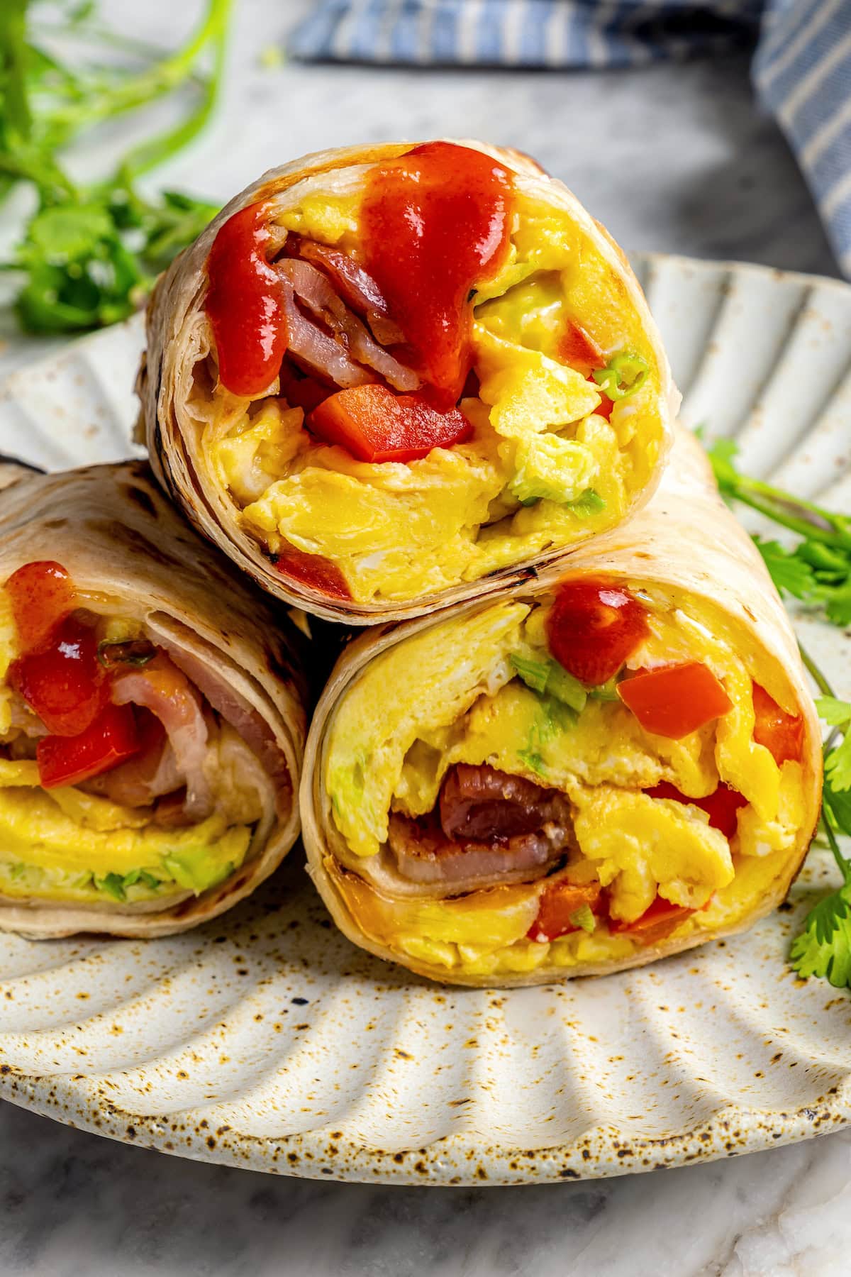 Freezer breakfast burritos stacked on plate