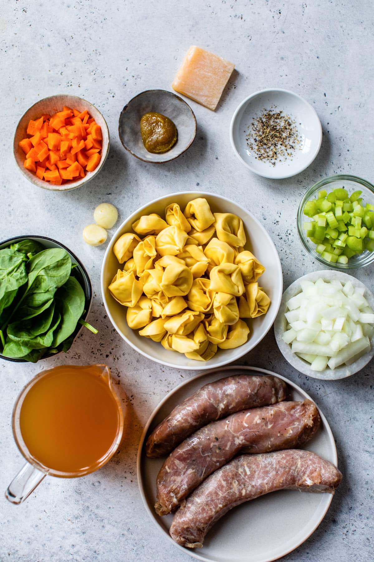 Sausage, spinach Tortellini, broth, onions, celery and carrots for making soup